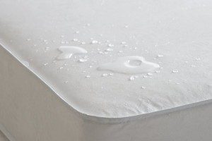 Baby proof bedroom: Waterproof mattress shown with droplets of water on top