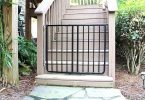 Outdoor baby gate: black gate at foot of stairs