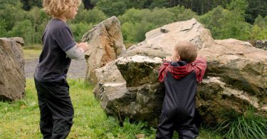 Camping with a baby: two young children playing in the countryside