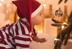 Crawling baby looking into Christmas bauble