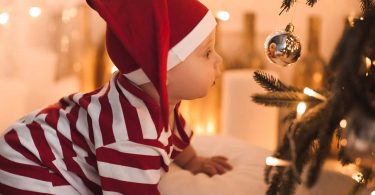 Crawling baby looking into Christmas bauble